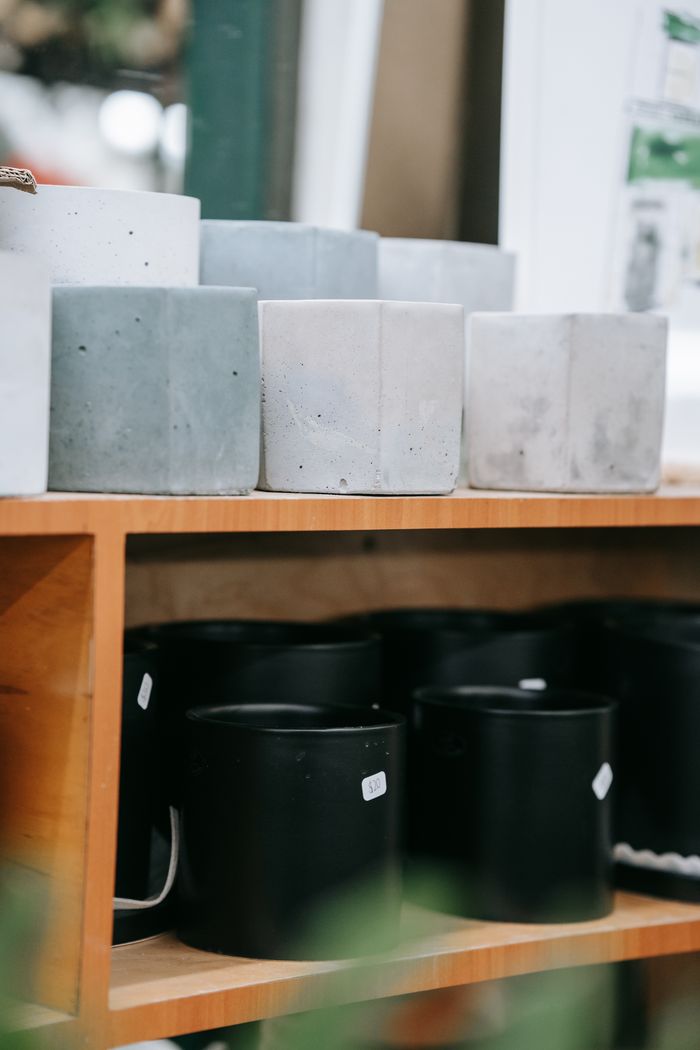 A variety of ceramic pots displayed on wooden shelves, perfect for a minimalist indoor decor.